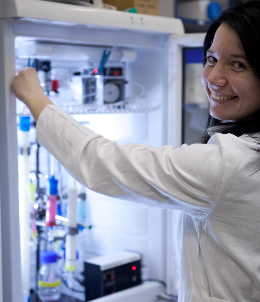 Portrait of a female researcher researcher taking a substance from a freezer