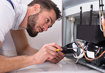 Male technician using tools to carry out ultra low temperature freezer repair