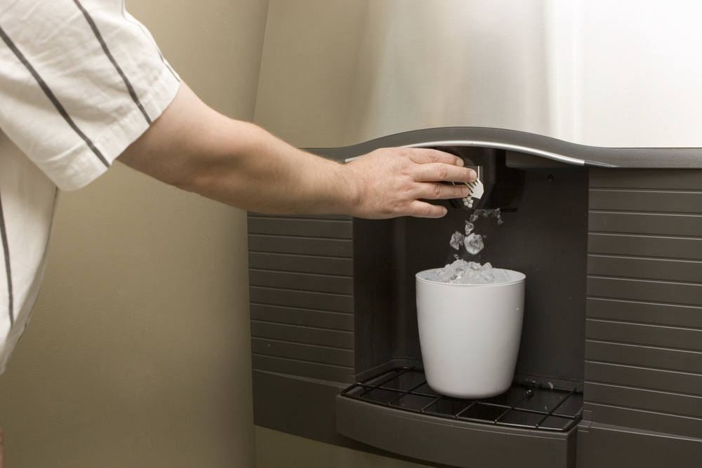 uniformed man filling an ice pitcher in a hospital refreshment station