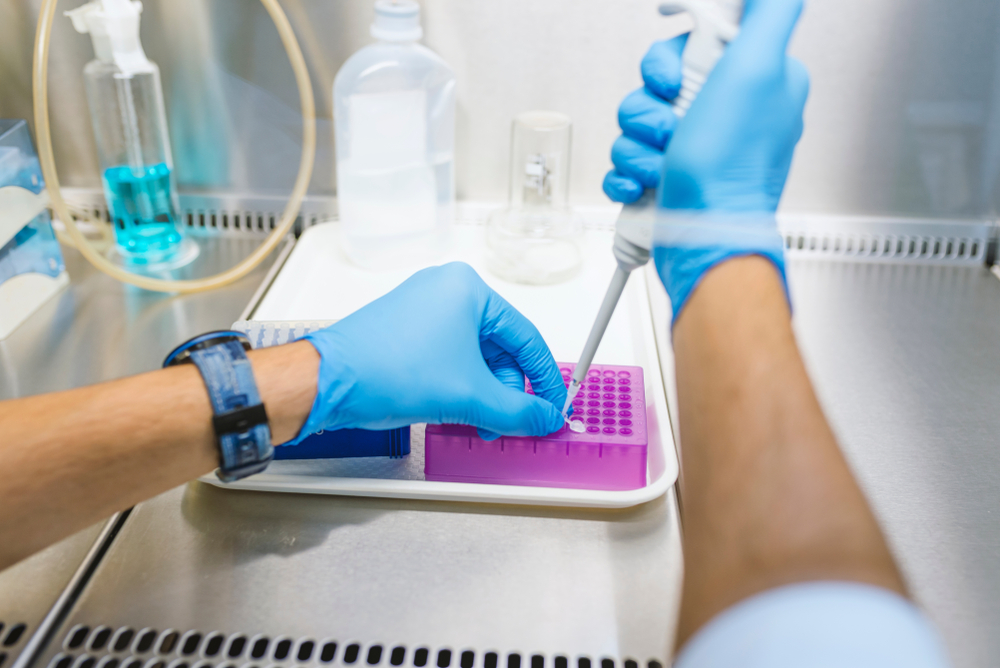 Microbiologist. Working in the fume hood. Researcher working with a Pipette in a Biochemistry Lab