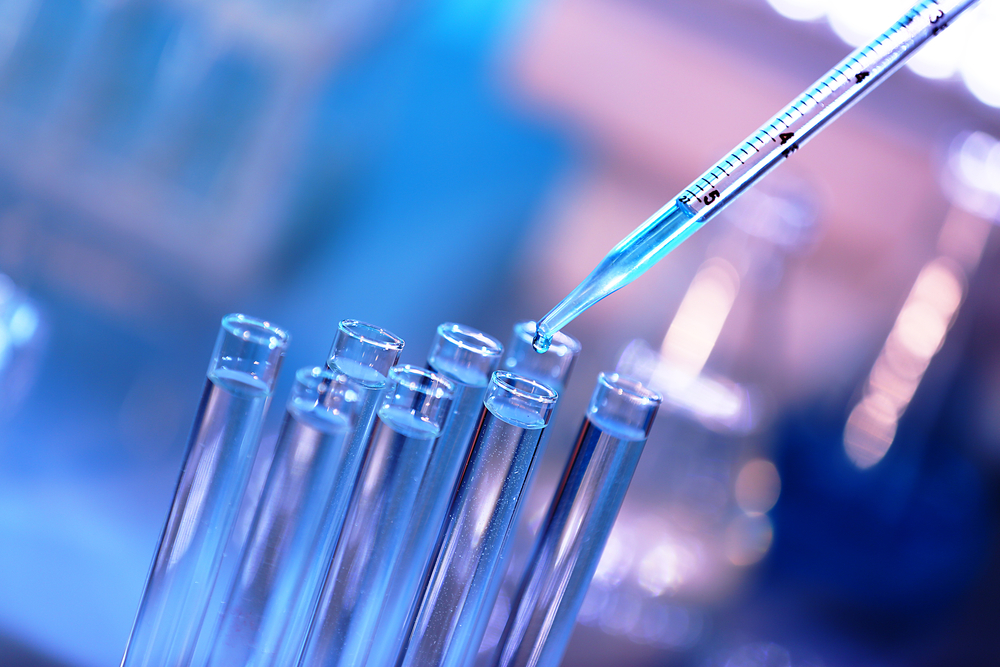 Pipette dropping a sample into a test tube