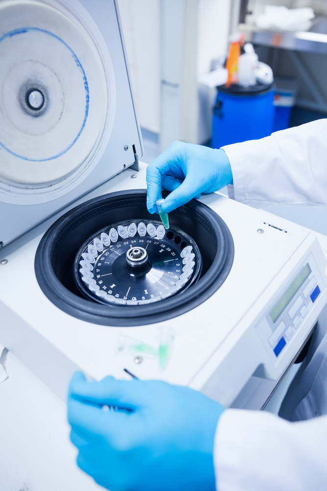 Close up of a chemist using a centrifuge in lab